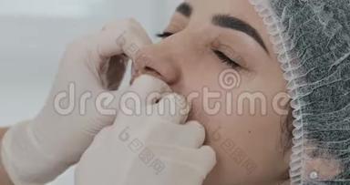美容医生的手在隆唇后按摩病人`嘴唇。 关门